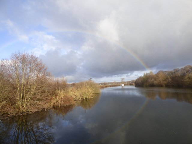 image of river with rainbow going from one bank to the other